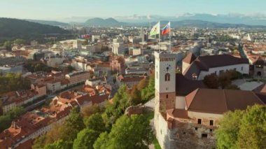 Slovenya 'nın eski Ljubljana kasabasının havadan görünüşü. Ljubljana kalesi, tarihi binalar ve Slovenya başkentindeki Ljubljanica nehrinin üzerindeki ünlü Üçlü Köprü. Arkaplanda güzel bir sıradağ