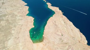 Hırvatistan 'ın Dalmaçya bölgesindeki Rab adasındaki Mag plajı. Mag plajının havadan görüntüsü. Terkedilmiş deniz suyuyla çevrili muhteşem bir sahil. Drone yörünge atışı