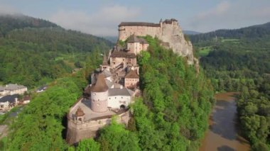 Slovakya 'da güneş doğarken Orava kalesinin hava görüntüsü. Orava Nehri kıyısındaki yüksek ve sarp kayalıklarda Ortaçağ Oravsky Hrad kalesi. 