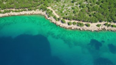 Hırvatistan 'ın Dalmaçya bölgesindeki Rab adasındaki turkuaz deniz suyuyla çarpıcı Adriyatik kıyılarının hava manzarası. Güzel deniz koyuna demirlemiş küçük bir tekne. Idyllic seyahat hedefi
