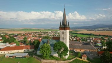 Slovakya 'nın Spissky Stvrtok kasabasındaki eski kilise. Yazın, tarihi bir kilise ve Slovakya 'da küçük bir köyle geleneksel kırsal manzaranın güzel hava manzarası. Drone yörünge atışı