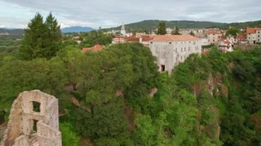 Hırvatistan 'ın Istria yarımadasındaki Pazin kasabasının tarihi manzarası. Tarihi çan kulesi, binalar ve Pazin kalesi.