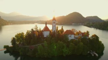 Slovenya Gölü, Aerial manzaralı. Slovenya 'da gün doğumunda küçük hac kilisesi olan güzel bir göl. Ada, sabah vakti Maria ve Kanlı Kale 'nin Hacı Kilisesi' ne doğru yola çıktı.