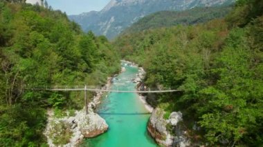 Slovenya 'daki Soca Nehri' nin zümrüt sularını kaplayan bir asma köprü, hava manzaralı. Soca nehir kanyonu Slovenya 'da kano gezisi için tercih edilen bir yerdir..