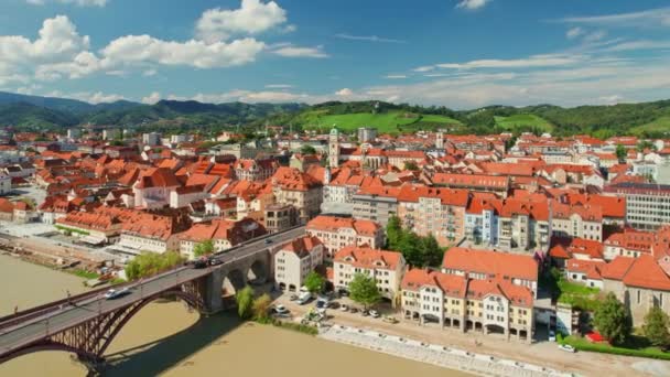 晴れた日 スロベニアのマリボル市街地を眺める マリボルはスロベニアで2番目に大きな都市です マリボル古い町の歴史的建造物とドラヴァ川を渡る橋 — ストック動画