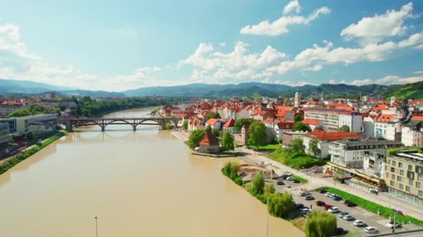 晴れた日 スロベニアのマリボル市街地を眺める マリボルはスロベニアで2番目に大きな都市です マリボル古い町の歴史的建造物とドラヴァ川を渡る橋 — ストック動画