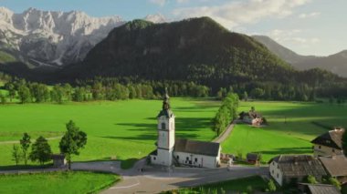 Arka planda Kamnik-Savinja Alpleri olan Ravenska Kocna Vadisi 'ndeki geleneksel Slovenya St. Andrei Kilisesi. Slovenya 'nın Zgornje Jezersko kentindeki cennet gibi Alp manzarasının havadan görünüşü