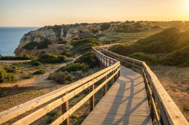 Güney Portekiz, Lagos 'taki Farol da Ponta da Piedade' de ahşap yol. Ponta da Piedade deniz feneri Lagos şehrinde gün batımında, Algarve, Portekiz