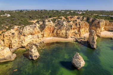 Portekiz 'in Algarve bölgesindeki güzel Praia da Marinha plajı. Güney Portekiz 'de kumlu sahil ve kayalık uçurumlar.