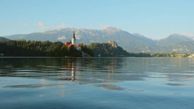 Slovenya Gölü, yaz manzaralı. Slovenya 'da güneş doğarken küçük bir adada hacca giden güzel bir göl. Ada, Maria ve Kanlı Kale 'nin Hacı Kilisesi ile kan gölüne döndü.