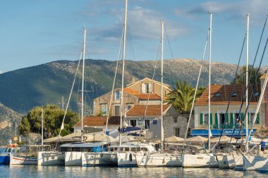 Kefalonia, Yunanistan - 5 Ekim 2022: Yunanistan 'ın İyon Denizi' ndeki Fiscardo, Cefalonia adasındaki geleneksel balıkçı köyüne demirlemiş yelkenli tekne ve yatlar.