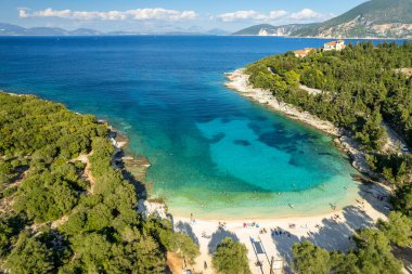 Aerial view of an amazing sea bay with beautiful Emplisi beach near Fiskardo town, Kefalonia island, Ionian sea, Greece. Aerial drone orbit shot. Perfect summer holidays destination