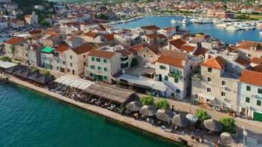 Hırvatistan 'ın Dalmaçya bölgesindeki Adriyatik Denizi' ndeki eski Tribunj kasabasının hava manzarası. Küçük adadaki Adriyatik Tribunj kasabası. Açık hava restoranları olan tarihi binalar..