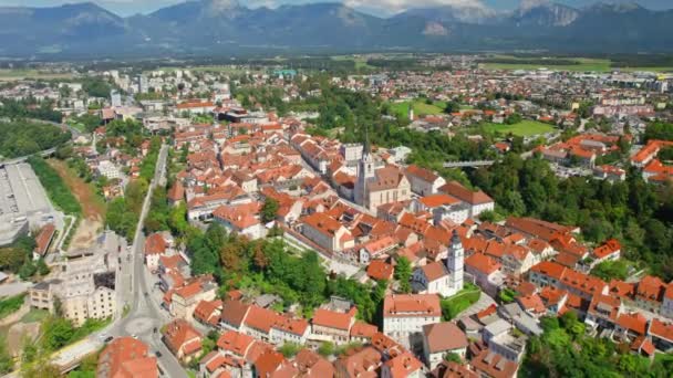 バックグラウンド スロベニアの山脈を持つクランジュ町の空中ビュー クランジュはスロベニアで3番目に大きな都市です 晴れた日のクランジュの街並み — ストック動画