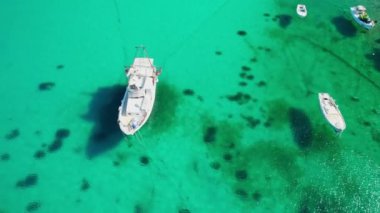 Kristal berrak deniz suyuna demir atan küçük balıkçı tekneleri. Hırvatistan 'ın Rab Adası' ndaki turkuaz suda demirli bir teknenin hava manzarası. Hırvatistan 'ın Dalmaçya bölgesindeki çarpıcı Adriyatik kıyılarının hava manzarası