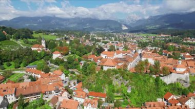 Slovenya 'daki Kamnik şehrinin havadan görüntüsü. Tepede küçük bir kale ve arkasında muhteşem Kamnik-Savinja Alpleri olan eski Kamnik kasabası.
