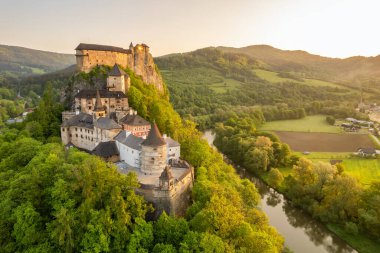 Slovakya 'da güneş doğarken Orava kalesinin hava görüntüsü. Orava Nehri kıyısındaki yüksek ve sarp kayalıklarda Ortaçağ Oravsky Hrad kalesi