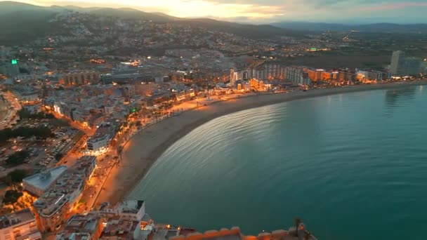 ペニスコラのビーチと城をツイライトで眺めるペニスコラは スペインのバレンシア州コスタデルアザハルで人気のある沿岸町です 中世スペインの町のドローンナイトショット — ストック動画