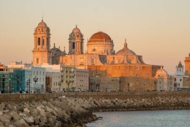 Cadiz, Endülüs, İspanya 'da günbatımında Santa Cruz Katedrali ve Atlantik Okyanusu kıyıları.