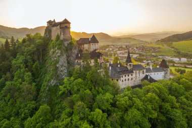 Slovakya 'da güneş doğarken Orava kalesinin hava görüntüsü. Orava Nehri kıyısındaki yüksek ve sarp kayalıklarda Ortaçağ Oravsky Hrad kalesi