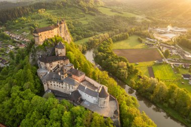 Slovakya 'da güneş doğarken Orava kalesinin hava görüntüsü. Orava Nehri kıyısındaki yüksek ve sarp kayalıklarda Ortaçağ Oravsky Hrad kalesi