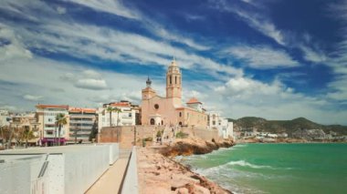 Sitges, Katalonya, İspanya 'da güneşli bir günde kıyı kasabası ve Iglesia de San Bartolome y Santa Tecla kilisesi. Yavaş sabit görüntü
