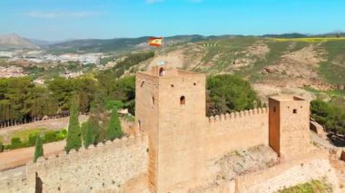 İspanya, Endülüs 'teki Antequera şehrindeki tarihi Alcazaba kalesinin hava manzarası. Eski kasabanın, Katolik kiliselerinin, tarihi binaların ve ortaçağ şatosunun üzerinde uçuyorlar.