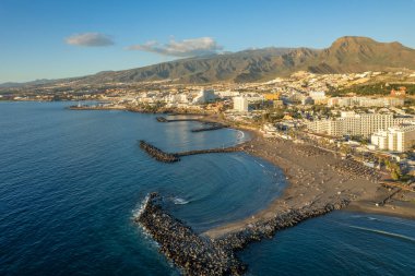 Gün batımında Adeje Playa de las Americas, Tenerife, Kanarya Adaları 'ndaki güzel sahil ve okyanus manzarası. Volkanı arka planda gezdir