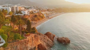 İspanya 'da güneş doğarken, Akdeniz kıyısında Costa del Sol kıyıları inanılmaz. Nerja, Endülüs, İspanya 'daki Playa Carabeo plajının hava manzarası. Lüks villalar, otel tesisi kompleksi ve güzel plaj.