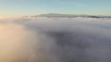 Güney Polonya 'da güneş doğarken görkemli Tatry dağlarıyla sabah sisinin üzerinde uçmak. Yüksek Tatras Ulusal Parkı 'nın hava manzarası