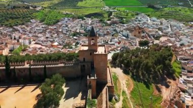 İspanya, Endülüs 'teki Antequera şehrindeki tarihi Alcazaba kalesinin hava manzarası. Eski kasabanın, Katolik kiliselerinin, tarihi binaların ve ortaçağ şatosunun üzerinde uçuyorlar.