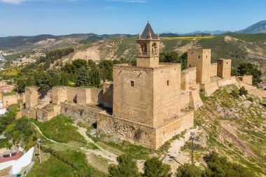İspanya, Endülüs 'teki Antequera şehrindeki tarihi Alcazaba kalesinin hava manzarası. Eski kasabanın, Katolik kiliselerinin, tarihi binaların ve ortaçağ şatosunun üzerinde uçuyorlar.