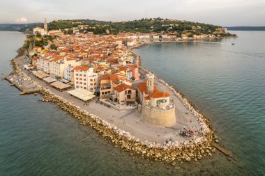 Slovenya 'da eski bir deniz feneri ve turkuaz deniz suyuyla Piran' ın hava manzarası. Slovenya 'nın Akdeniz kıyısındaki Piran kenti.