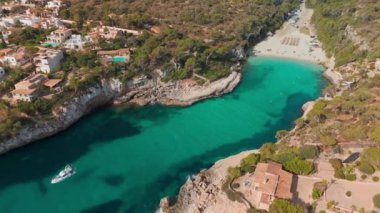 İspanya 'nın Balearic Adaları, Mallorca' daki Cala Llombards plajının yukarıdan görünüşü. Turkuaz su limanı ve beyaz kumsal sahili ile Akdeniz kıyılarını sersemletiyor. Mallorca seyahat noktaları