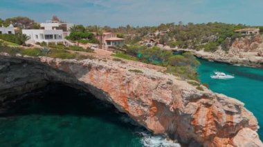 İspanya 'nın Balearic Adaları, Mallorca' daki Cala Llombards plajının yukarıdan görünüşü. Turkuaz su limanı ve beyaz kumsal sahili ile Akdeniz kıyılarını sersemletiyor. Mallorca seyahat noktaları