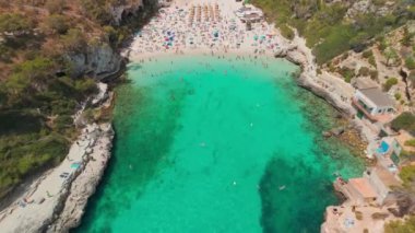 İspanya 'nın Balearic Adaları, Mallorca' daki Cala Llombards plajının yukarıdan görünüşü. Turkuaz su limanı ve beyaz kumsal sahili ile Akdeniz kıyılarını sersemletiyor. Mallorca seyahat noktaları
