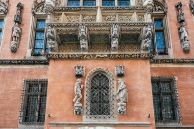 Polonya 'nın Wroclaw kentindeki zengin mimari mirası vurgulayan karmaşık oyma ve heykellerin yer aldığı süslü tarihi bir binanın mimari görünüşü.