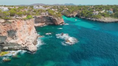 İspanya, Balearic Adaları, Mallorca 'daki Cala Llombards plajının hava manzarası. Turkuaz su limanı ve beyaz kumsal sahili ile Akdeniz kıyılarını sersemletiyor. Mallorca seyahat noktaları