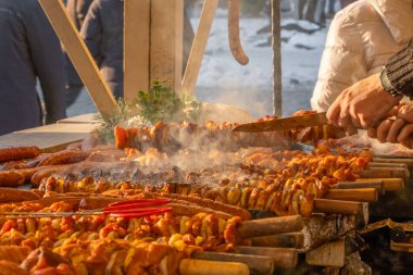 Polonya 'nın Krakow kentindeki bir Noel pazarında geleneksel Polonya sokak yemekleri. Bir şef geleneksel ızgara ve pişirilmiş ette rustik patates hazırlar. Aralık 'ta Yıllık Noel Fuarı