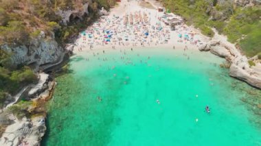 İspanya 'nın Balearic Adaları, Mallorca' daki Cala Llombards plajının yukarıdan görünüşü. Turkuaz su limanı ve beyaz kumsal sahili ile Akdeniz kıyılarını sersemletiyor. Mallorca seyahat noktaları