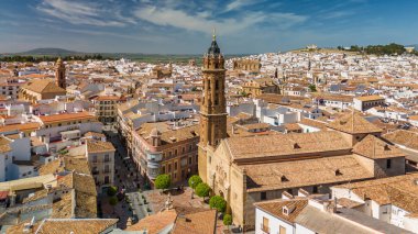 Aerial view of the historic center of Antequera city in Andalusia, Spain. Flying over the old town, Catholic churches, historic buildings, and the medieval Alcazaba fortress. clipart