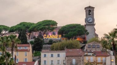 Cannes şehrinin işareti, Fransız Riviera 'sındaki ünlü tatil beldesi, Cote d Azur, Fransa. Cannes 'da gün be gece şehrin aydınlanması. Geleneksel Cannes Film Festivali 'nin sembolü. 4k zaman dilimi