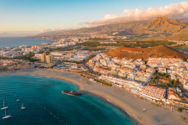 Gün batımında Adeje Playa de las Americas, Tenerife, Kanarya Adaları 'ndaki güzel sahil ve okyanus manzarası. Volkanı arka planda gezdir