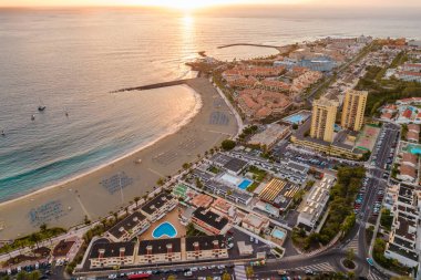 Gün batımında Adeje Playa de las Americas, Tenerife, Kanarya Adaları 'ndaki güzel sahil ve okyanus manzarası. Volkanı arka planda gezdir