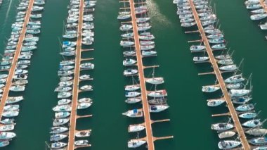 Kenetlenmiş yelkenlilerin hava görüntüsü. Limanda demirlemiş beyaz tekne ve yatların en üst görüntüsü. Limanda bir tekne. Tekneli liman. Yörünge atışı