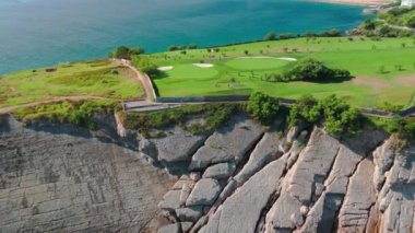 Santander, Cantabria 'daki Cabo Menor' da golf sahası, kuzey İspanya. Yarımadadaki çarpıcı golf sahalarının hava manzarası, kayalık kayalıklar ve Santander şehrinin manzaralı manzarası..