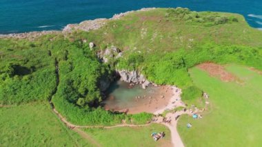 İspanya 'nın kuzeyinde, Asturias' taki Gulpiyuri plajı. Eşsiz Playa de Gulpiyuri 'nin havadan görünüşü denizden ayrılmış ve yemyeşil çayırlarla çevrili gizli bir lagün..