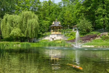 Fountain in Szczawnica city park during summer in Pieniny, Poland. Szczawnica is one of the oldest and most beautiful spa resorts in Poland. Lush and scenic city park. clipart