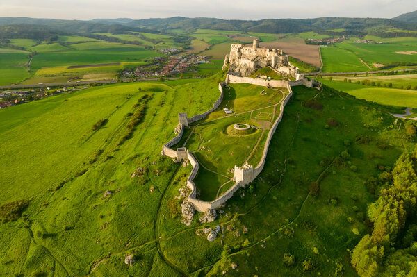 Вид с воздуха на замок Спис на восходе солнца, объект всемирного наследия ЮНЕСКО, Словакия. Средневековый замок Спиского града. Замок Спис в городе Списке-Подградье в Словакии.