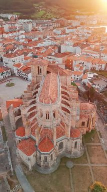 İspanya 'nın kuzeyinde Cantabria' da gün batımında Biscay Körfezi 'nde bulunan pitoresk bir liman şehri olan Castro Urdiales' in hava manzarası. Santa Maria de la Asuncion 'un güzel gotik kilisesi 